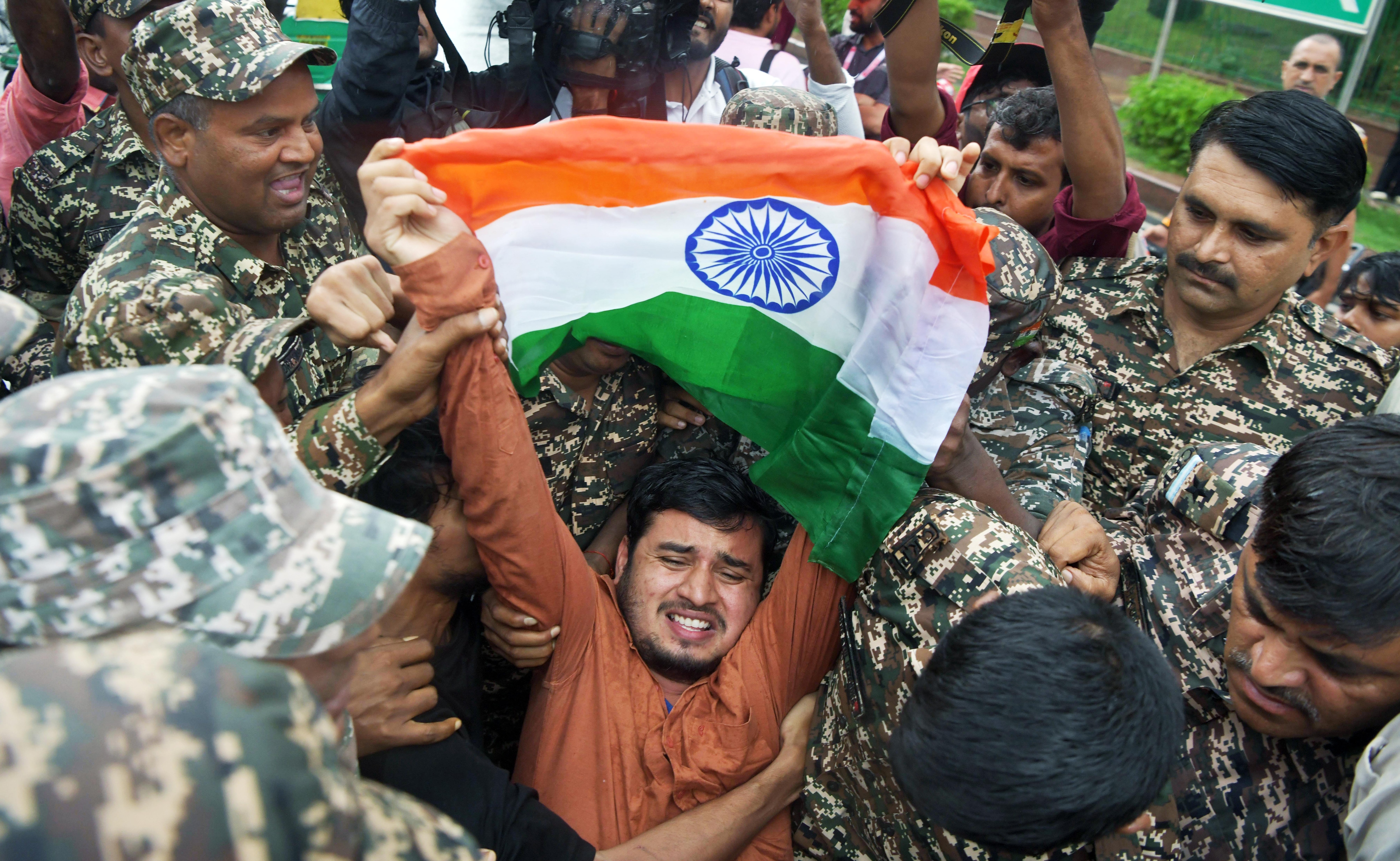 Security personnel detain a protester at Connaught Place on Thursday.