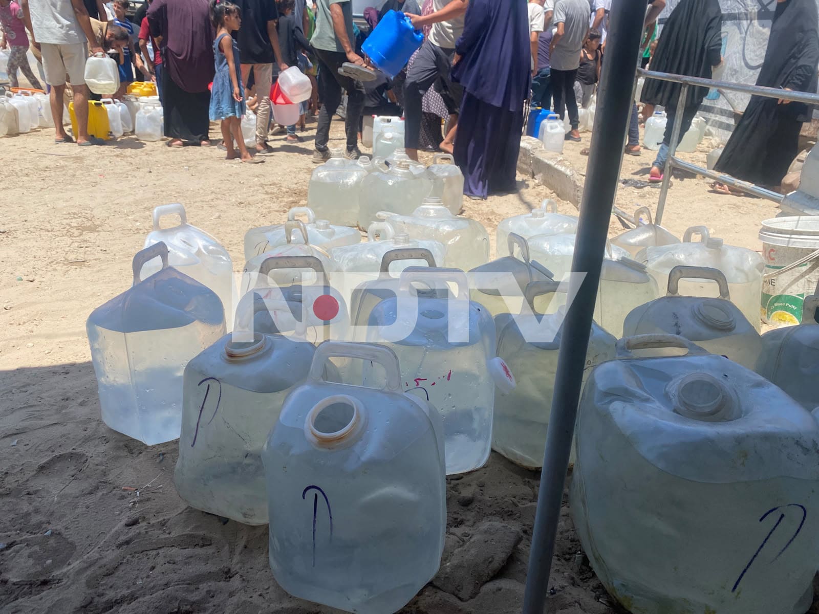 People in Gaza line for hours to collect drinkable water. People in Gaza line for hours to collect drinkable water.