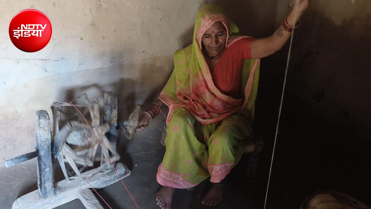 चरखे पर कताई करती गांव की महिला