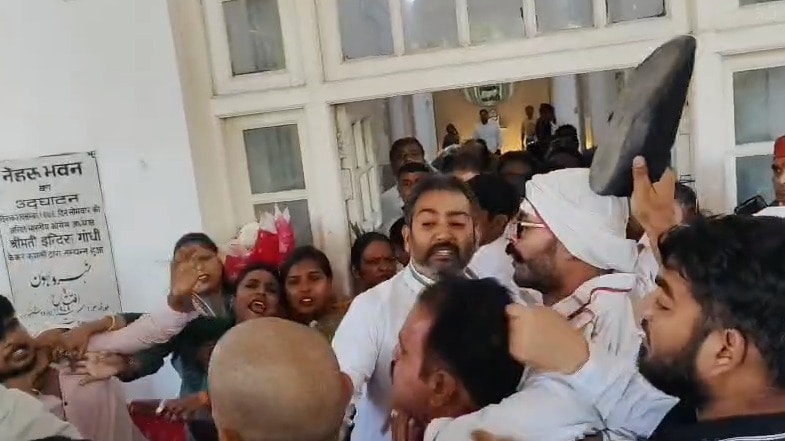 हंगामे के बीच हाथ में जूता लिए कांग्रेस कार्यकर्ता.