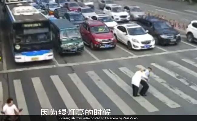 Watch: Cop Carries Elderly Man Across Road In Viral Video