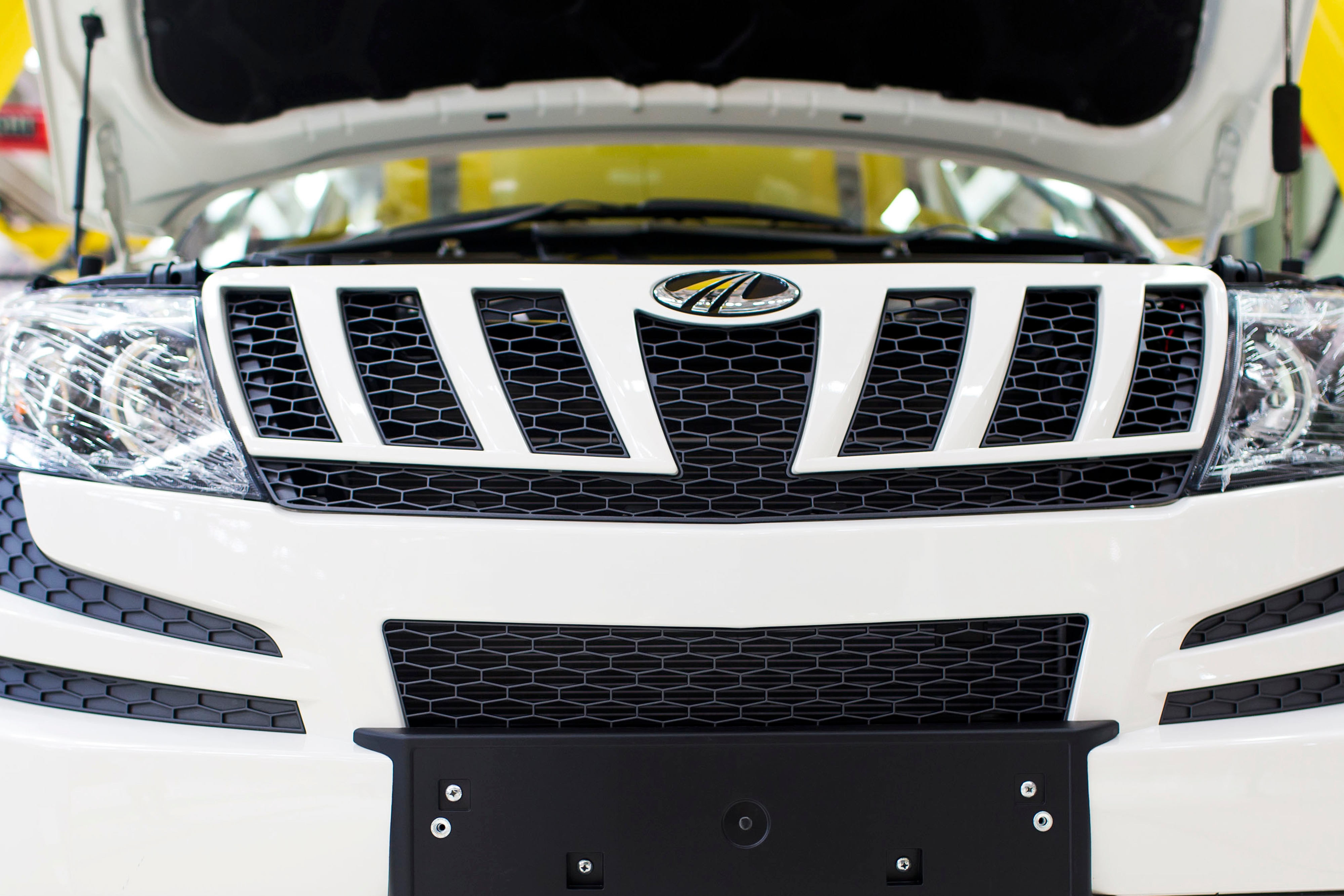A Mahindra and Mahindra Ltd. badge sits above the front grill of XUV 500 sport-utility vehicle (Photographer: Udit Kulshrestha/Bloomberg )