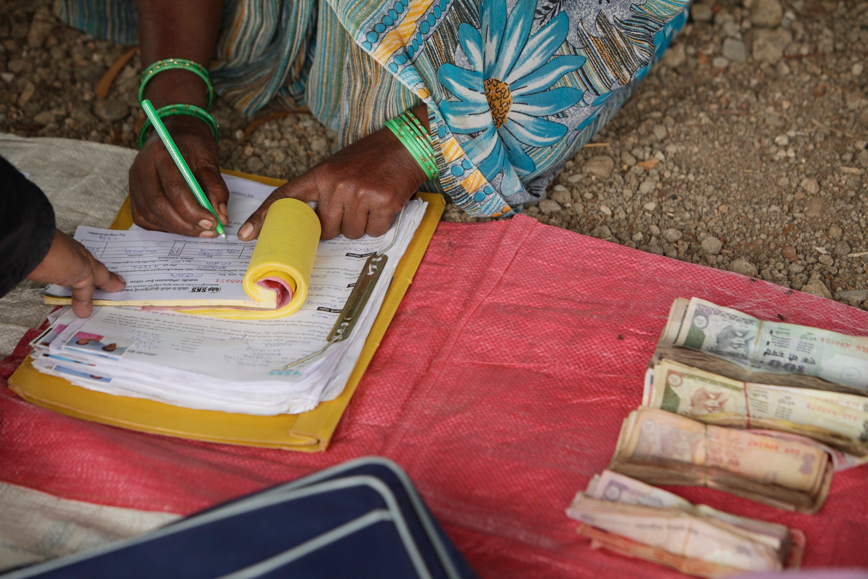 A woman signs a register to receive a loan during a meeting organized by SKS Microfinance Ltd. (Photographer: Adeel Halim/Bloomberg)