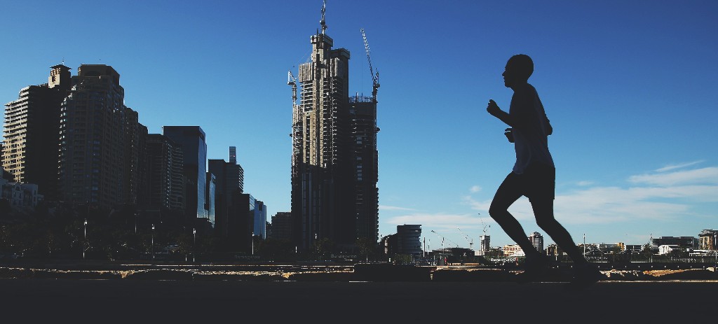 A jogger runs past buildings under construction. (Photographer: Brendon Thorne/Bloomberg)