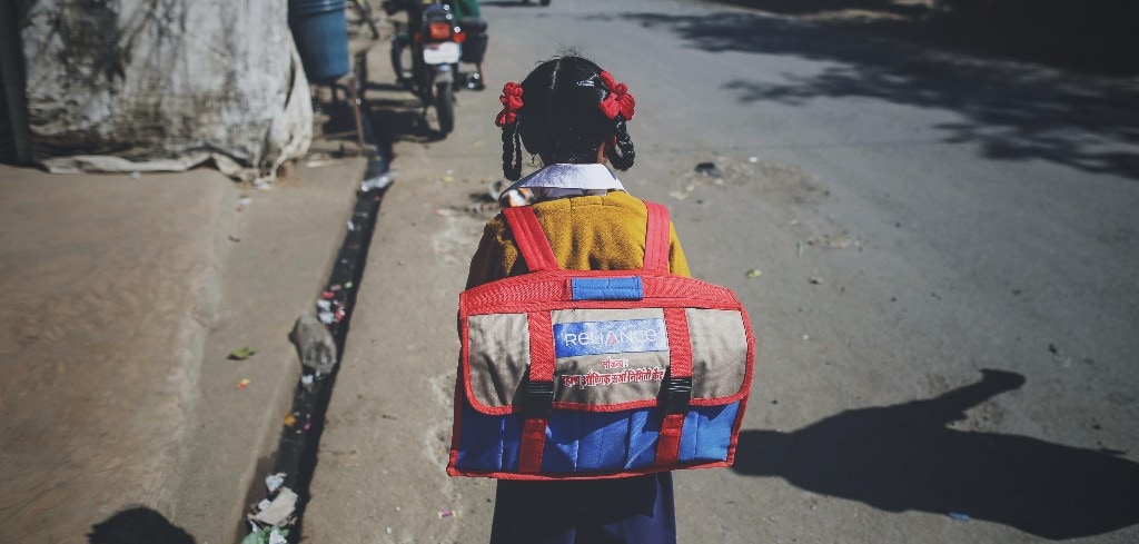 A schoolgirl walks along Dahanu Road in Kainad, Maharashtra, India (Photographer: Dhiraj Singh/Bloomberg)