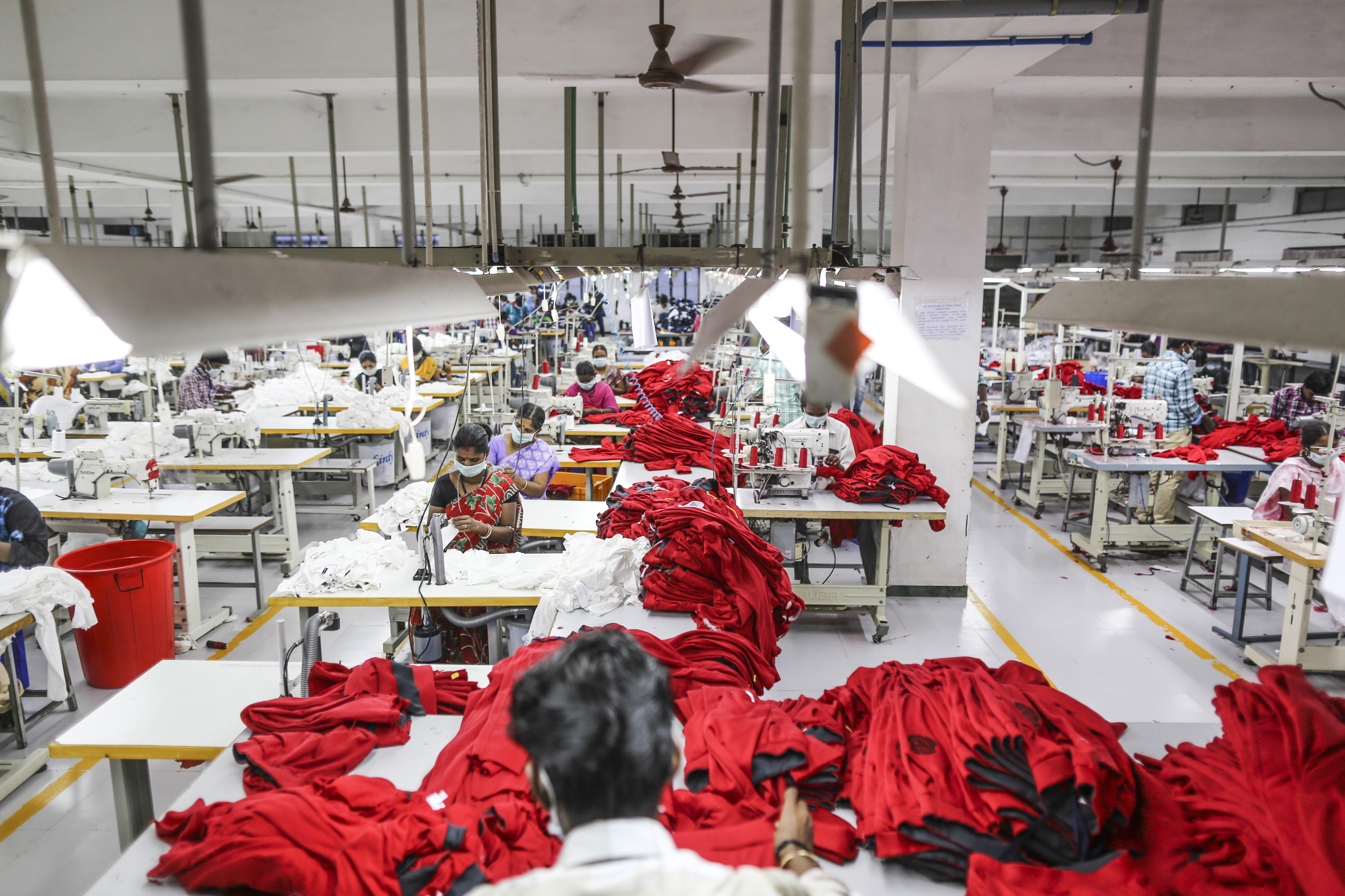 Employees use sewing machines on a production line at and apparel factory in Tamil Nadu, India. (Photographer: Dhiraj Singh/Bloomberg)