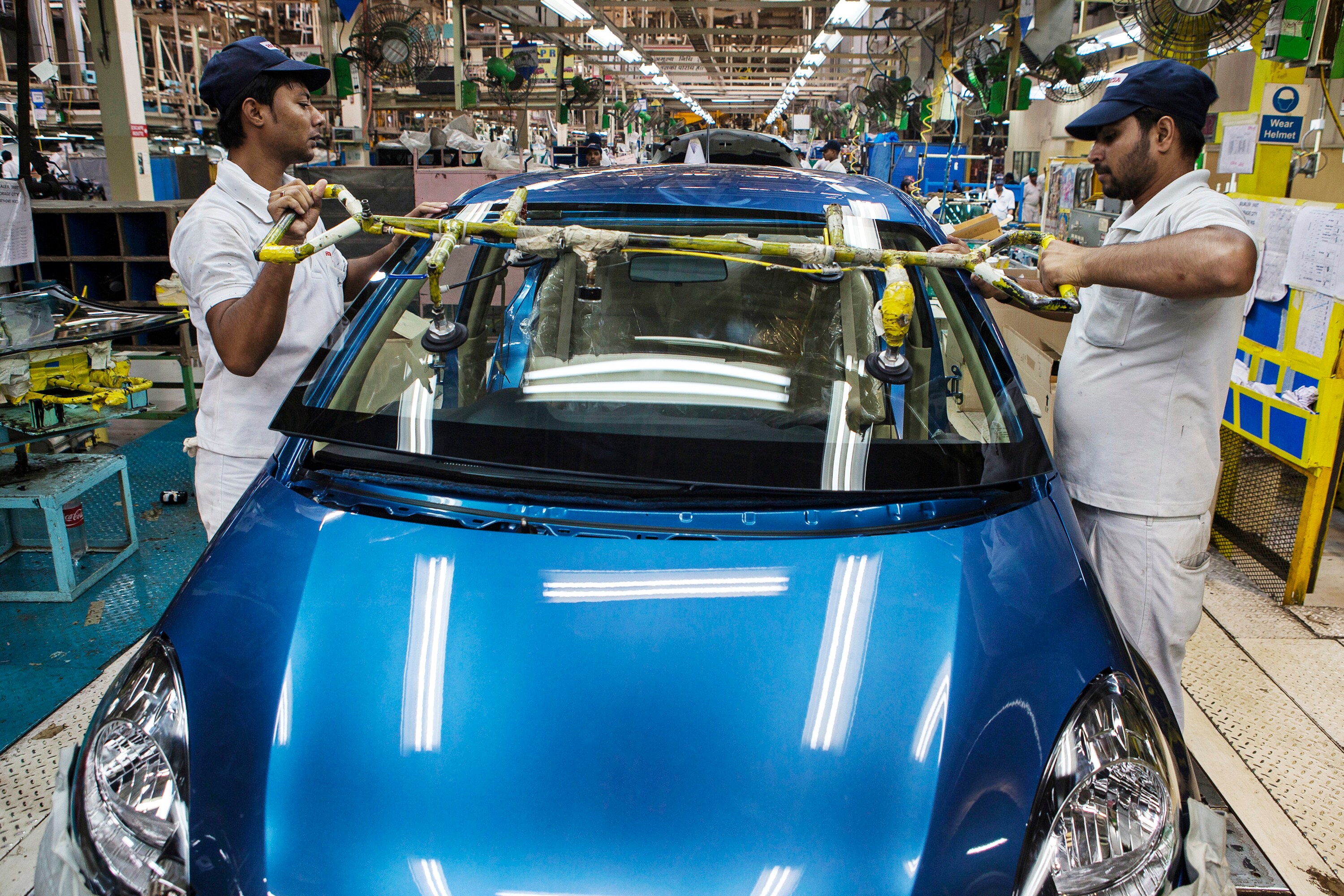 Employees fit a front windscreen to a Honda Motor Co. Amaze vehicle (Photographer: Prashanth Vishwanathan/Bloomberg)