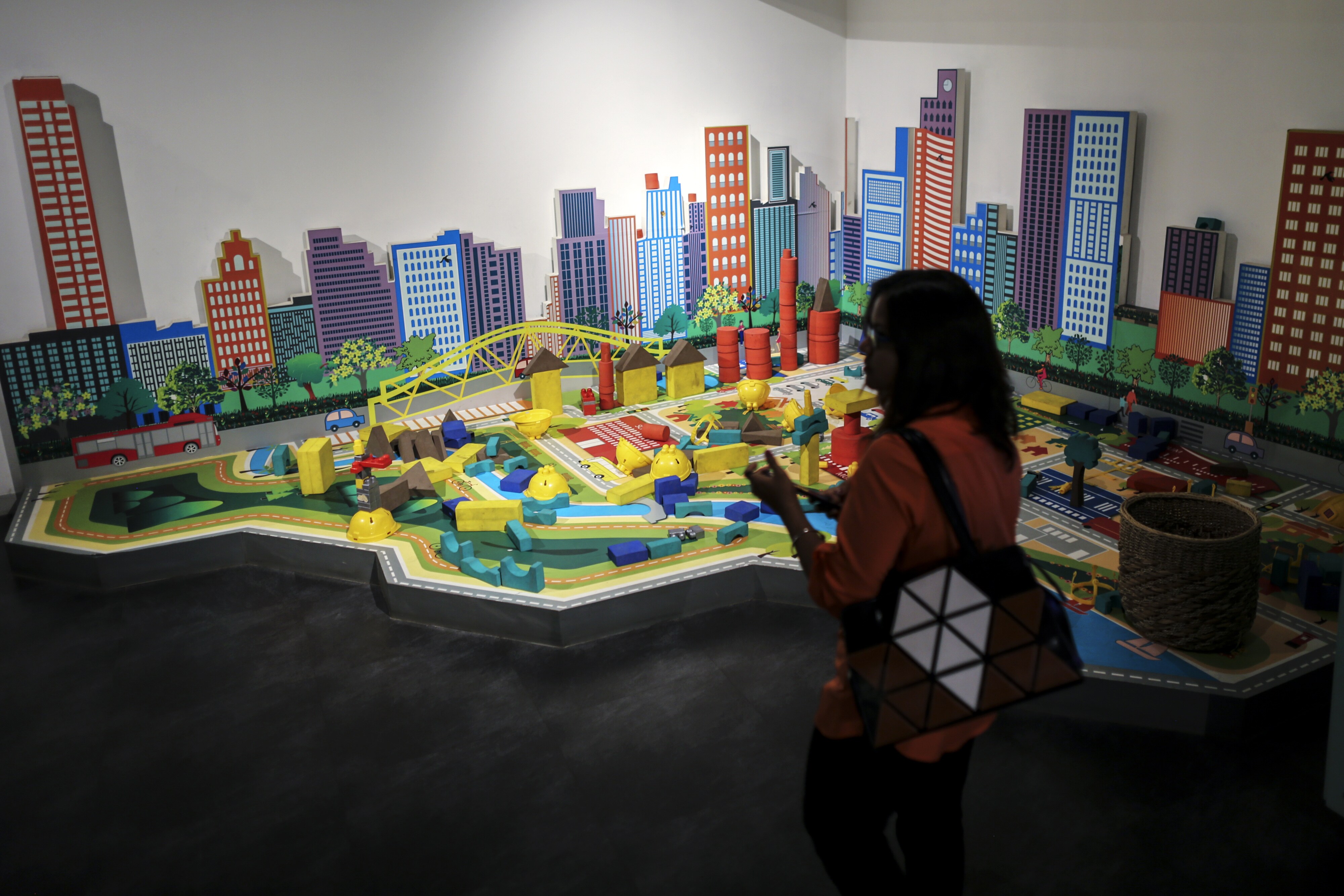 A woman walks near a model in a Lodha Group showroom (Photographer: Dhiraj Singh/Bloomberg)