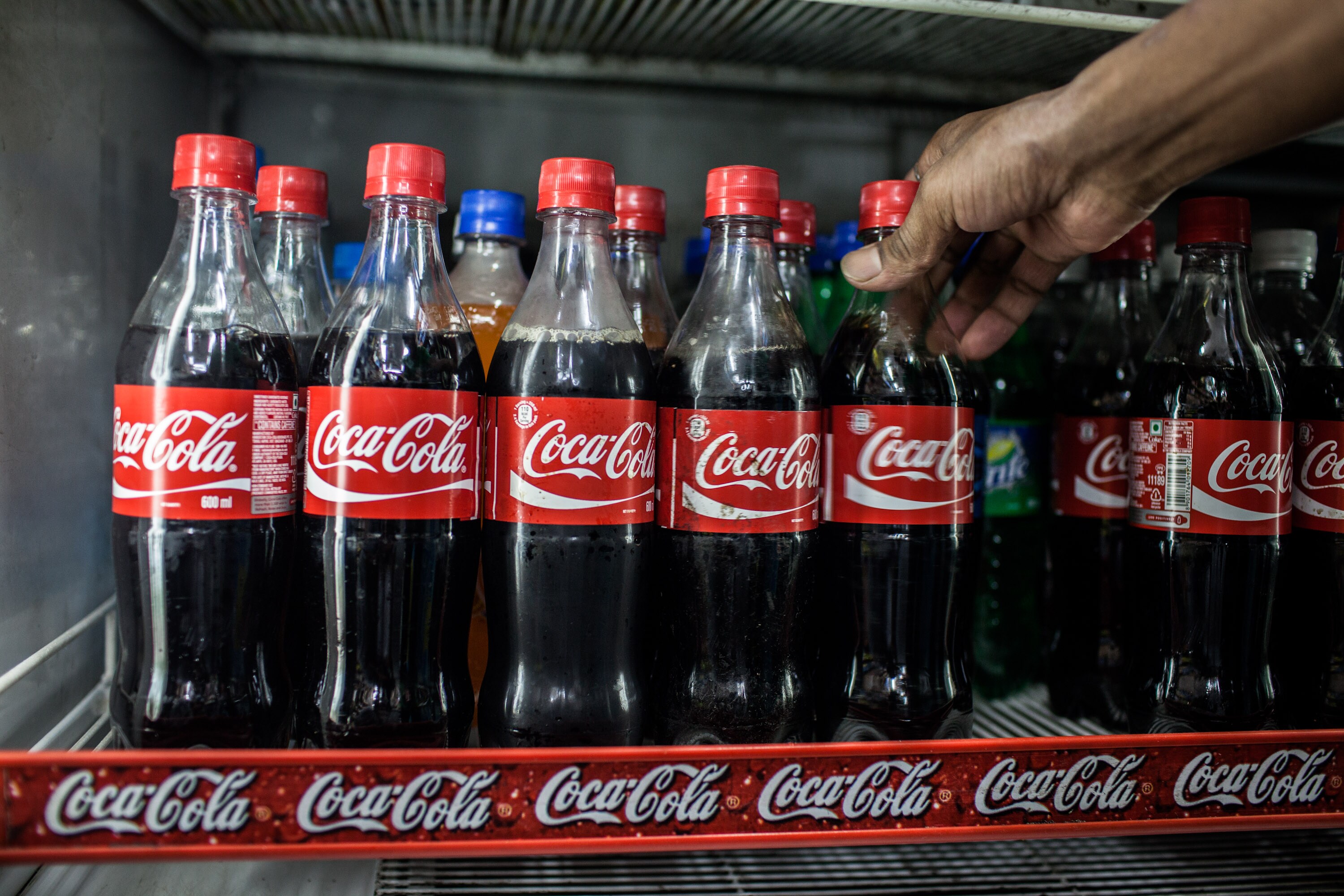 Coca-Cola beverages are placed on a shelf in a store in New Delhi, India. (Photographer: Sanjit Das/Bloomberg)