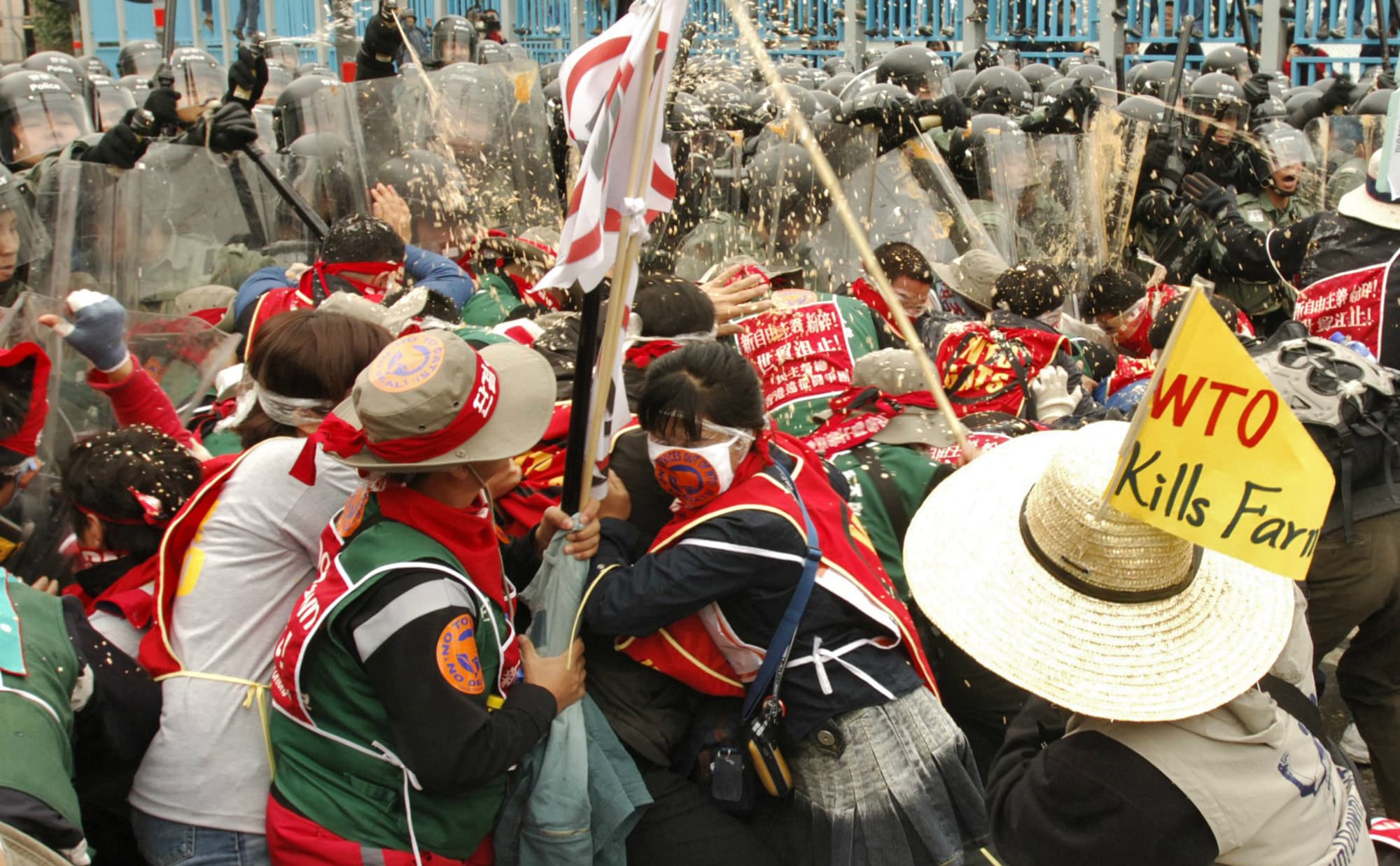 South Korean trade unionists scuffle with riot police and are hit with pepper spray during protests against the WTO's Sixth Ministerial Conference in Hong Kong, China, December 14, 2005. (Photographer: Michael Caronna/Bloomberg News )