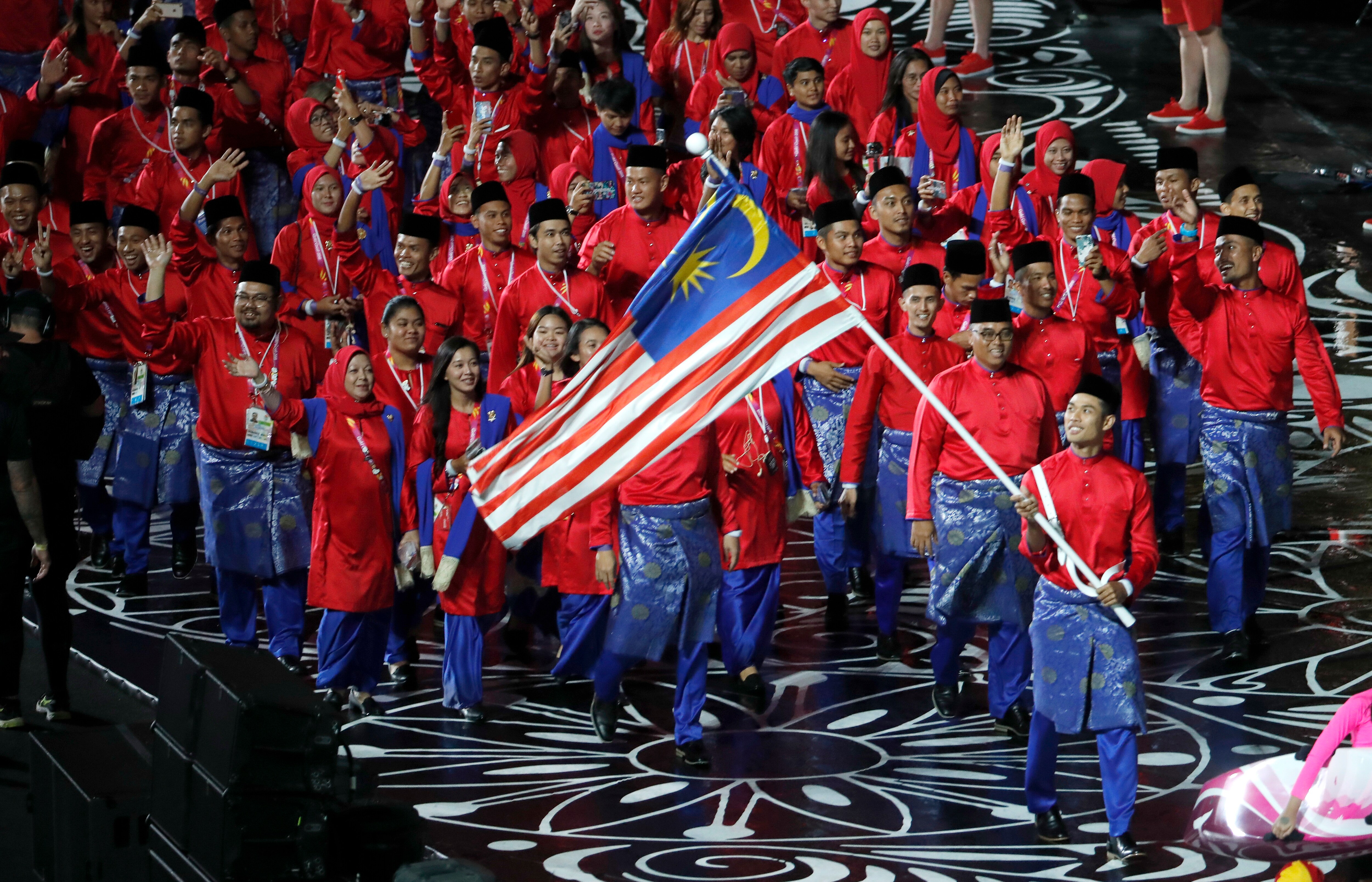 Team Malaysia is lead by flag-bearer Muhammad Hakimi Ismail at Carrara Stadium for the opening ceremony of the 2018 Commonwealth Games.