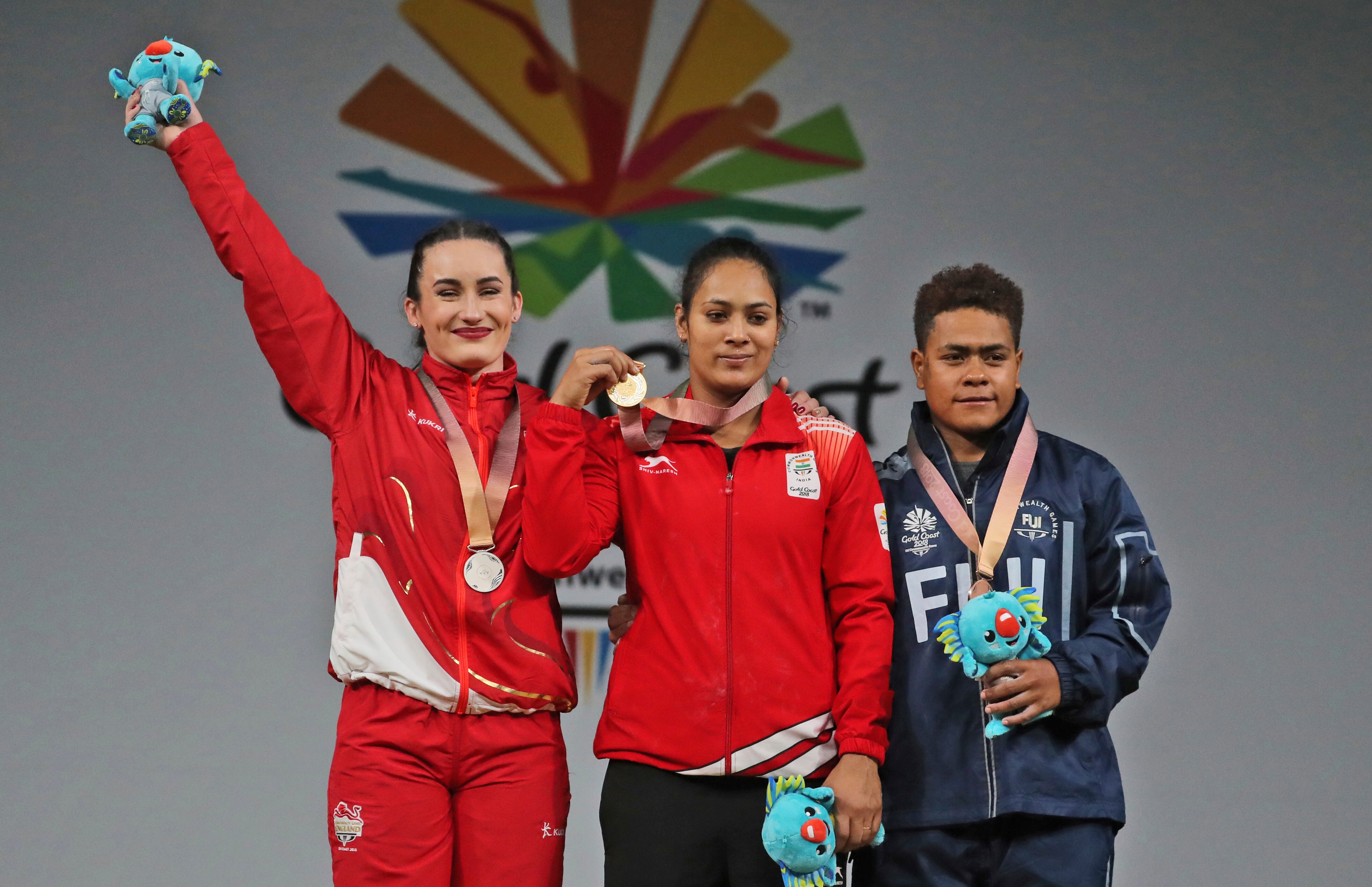 India's Women's 69Kg Weightlifting Gold medalist Punam Yadav, center, stands with England's Silver medalist Sarah Davies, left, and Fiji Bronze medalist Apolonia Vaivai during medal ceremony at the Commonwealth Games in Gold Coast, Australia, Sunday
