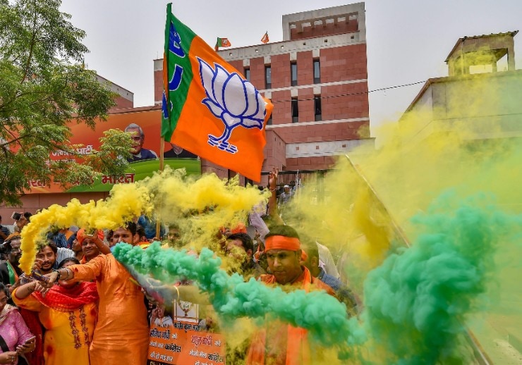 BJP workers celebrate the party's lead during counting of votes for Karnataka Assembly elections, at the party headquarters in New Delhi. (Photographer: Manvender Vashist/PTI)
