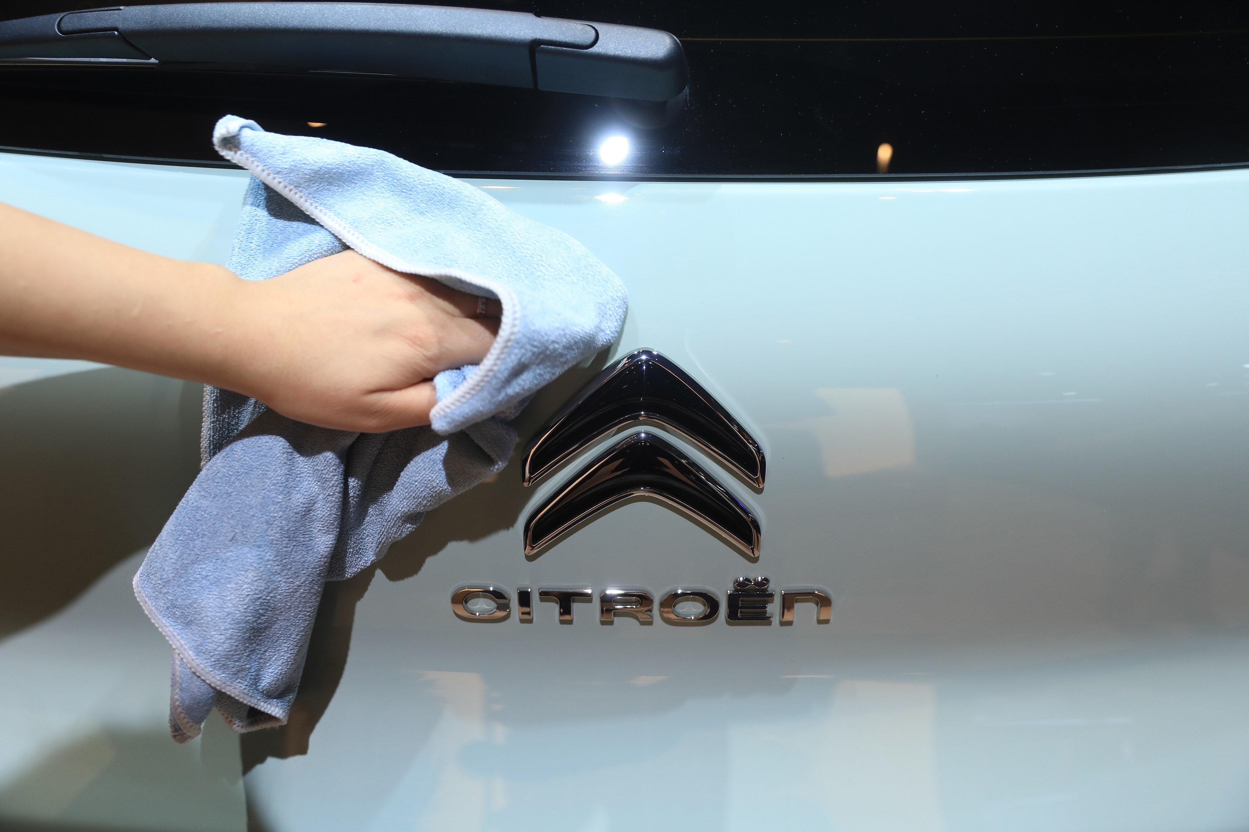 An employee polishes the badge of a Citroen C3 Aircross automobile, manufactured by PSA Peugeot Citroen. (Photographer: Krisztian Bocsi/Bloomberg)