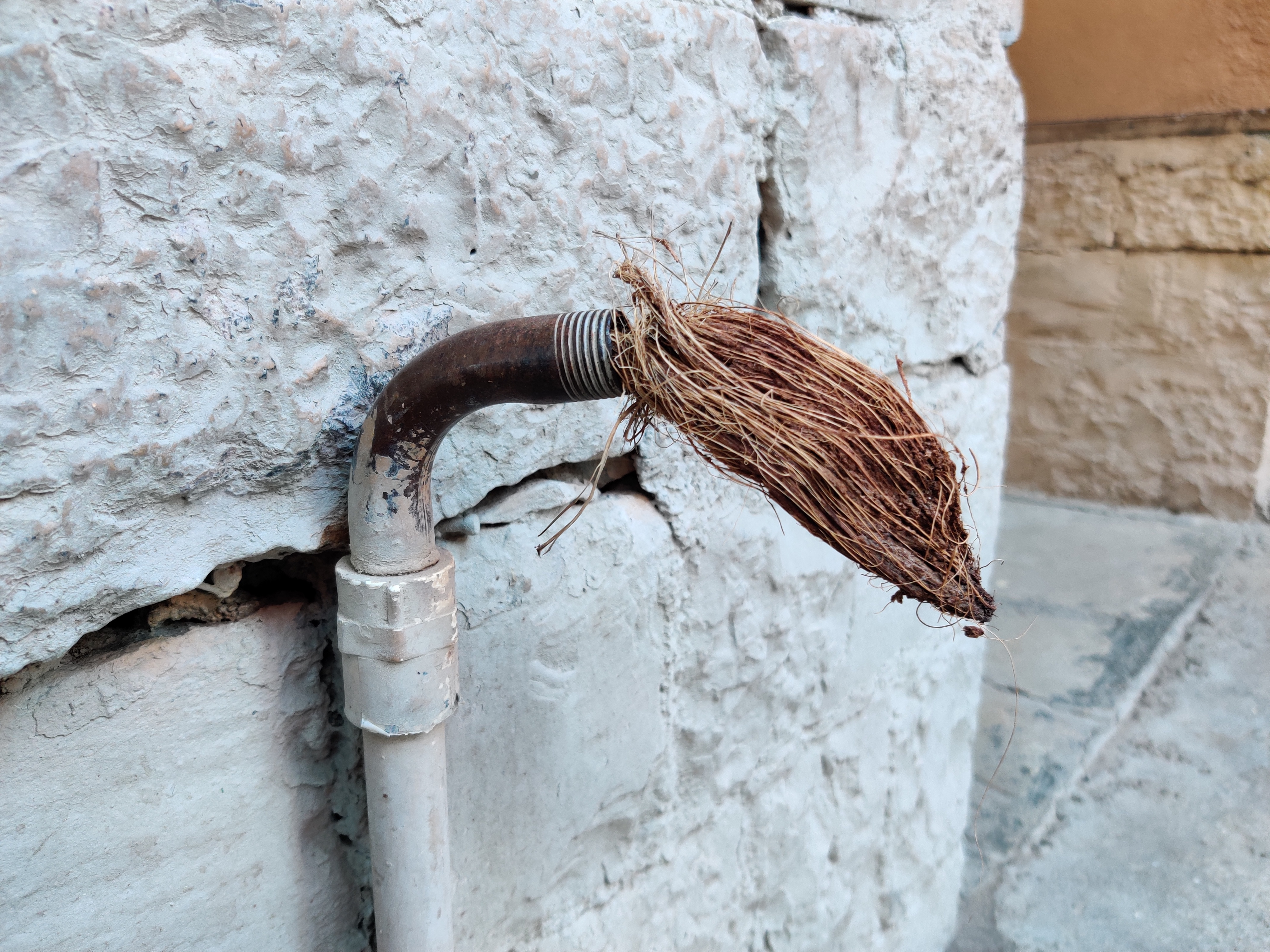 Picture of an open-ended water outlet, capped with coconut instead of tap. Picture Credit: Parth MN