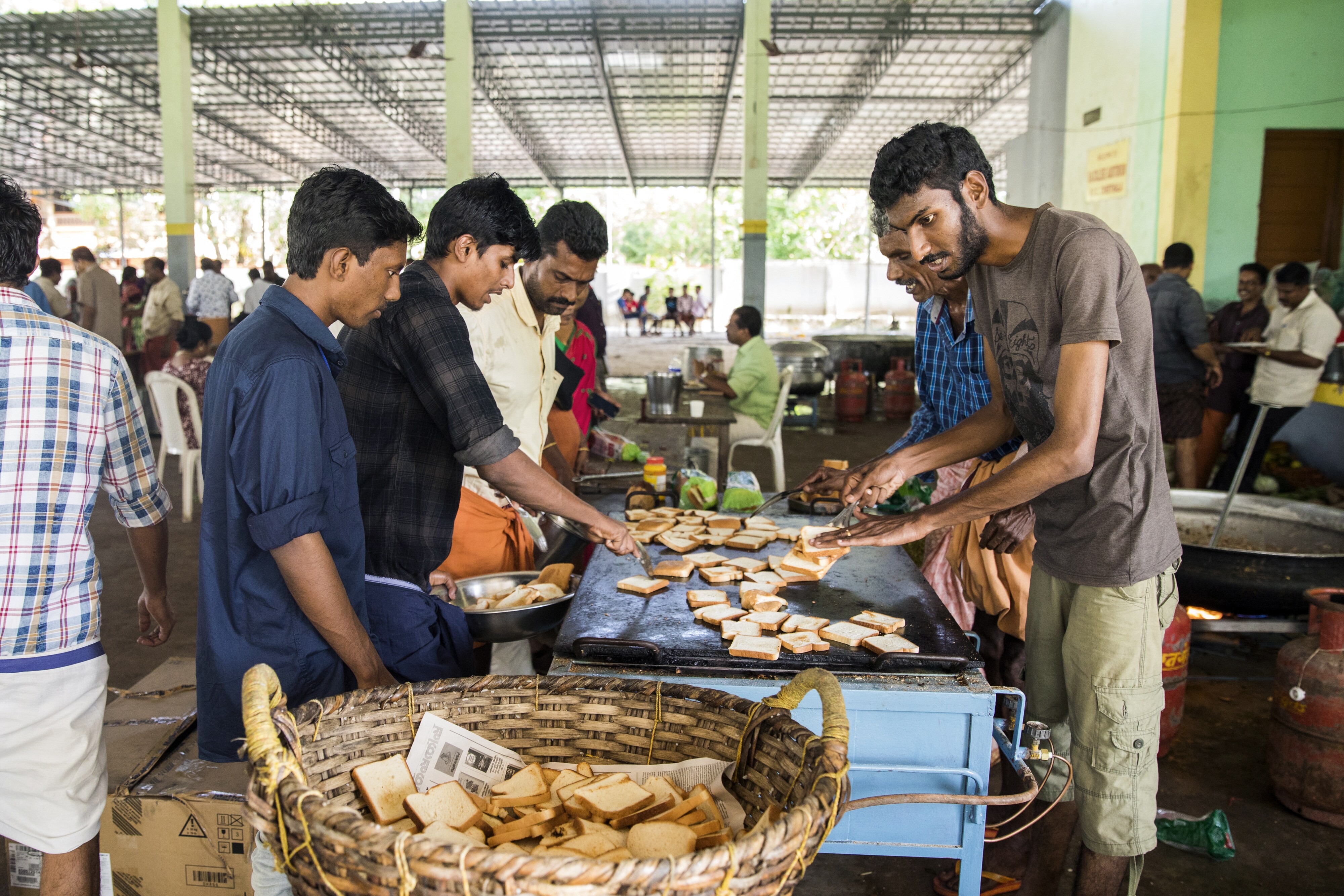 Volunteers prepare and serve food to flood victims in Alappuzha, Kerala, on Aug. 23, 2018. (Photographer: Prashanth Vishwanathan/Bloomberg)