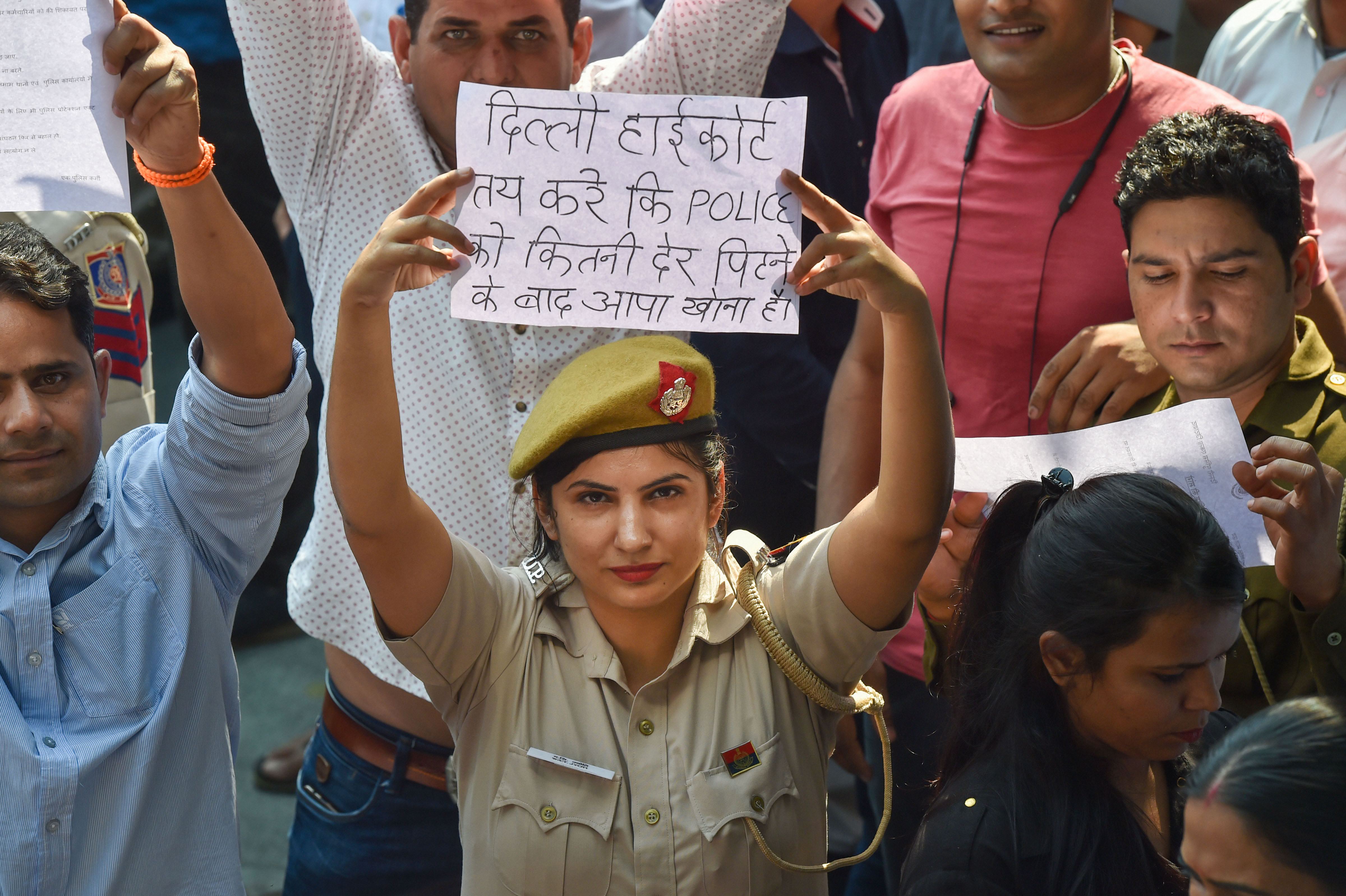 A Delhi Police woman displays a placard during a protest (Source: PTI)
