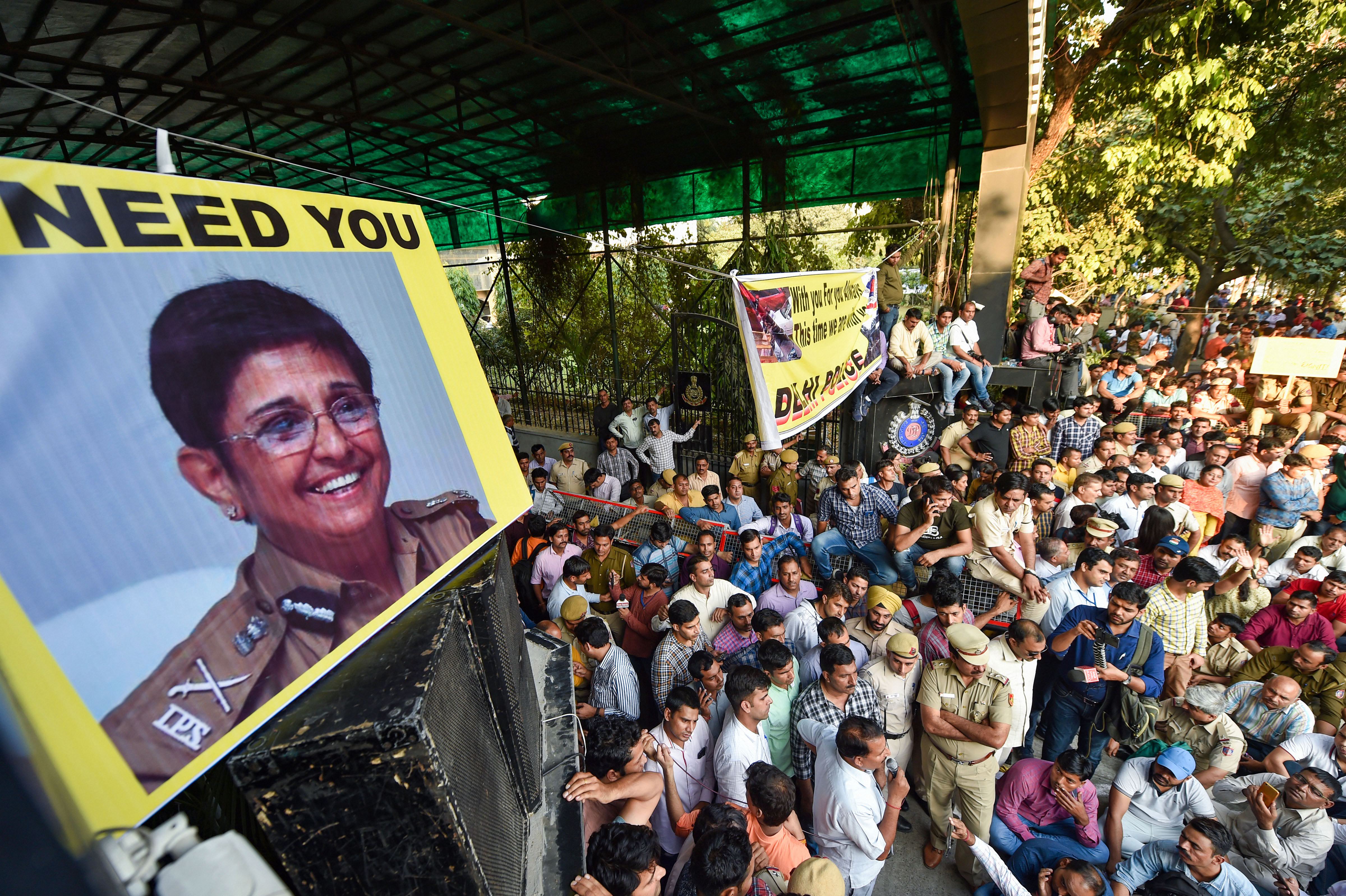 Police personnel display pictures of former IPS officer Kiran Bedi during a protest (Source: PTI)