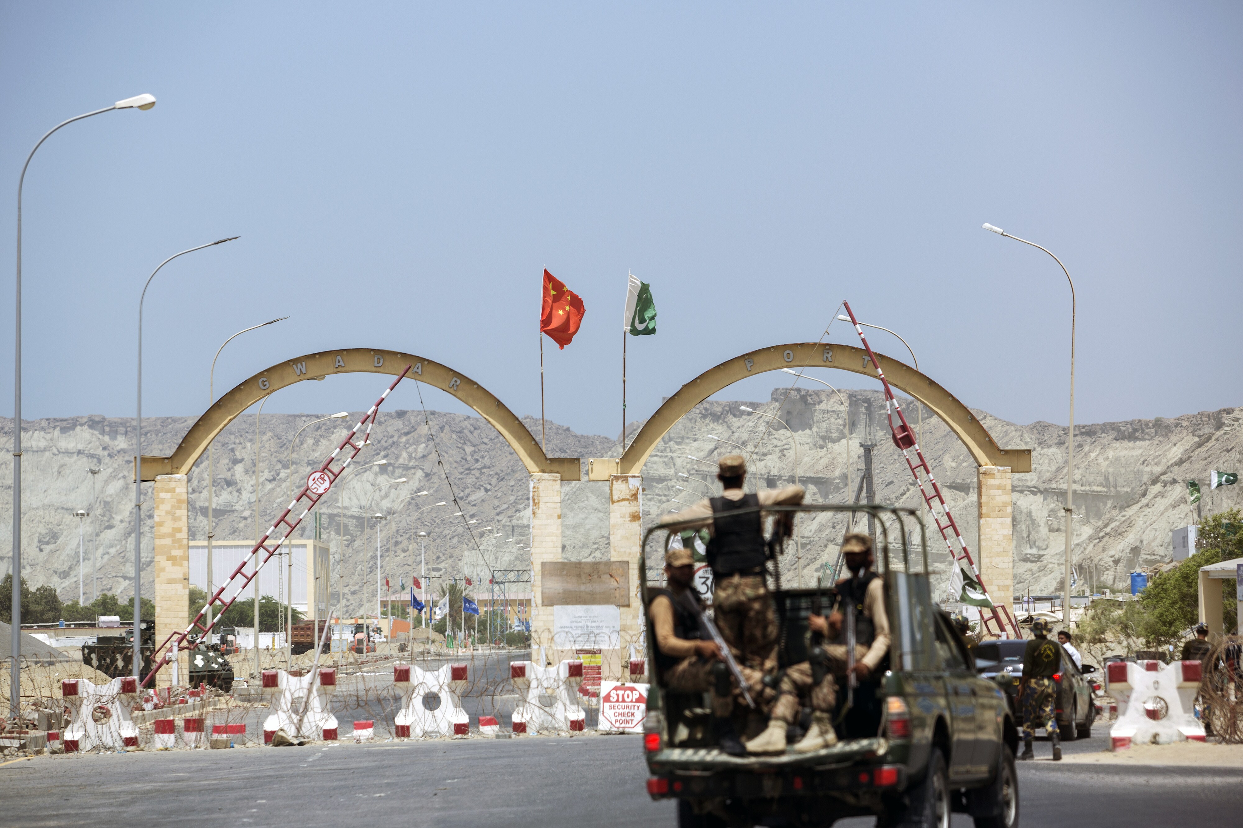 Security forces stand guard at an entrance to Gwadar Port, in Balochistan, Pakistan. (Photographer: Asim Hafeez/Bloomberg)