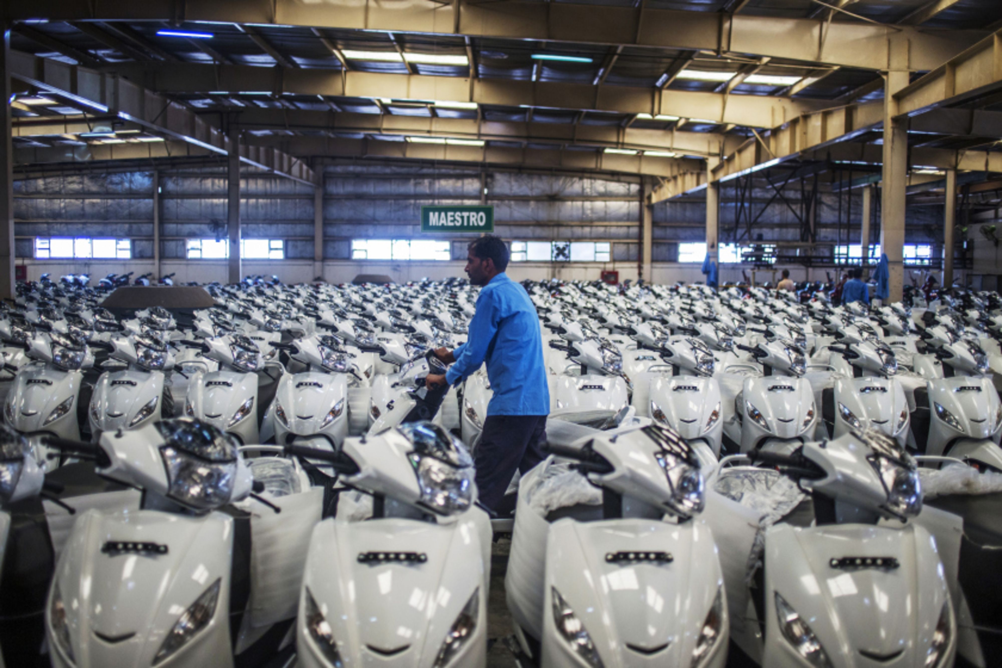 A workers wheels a scooter through the dispatch bay of the Hero MotorCorp plant in Gurugram, Haryana, India. (Prashanth Vishwanathan/Bloomberg)
