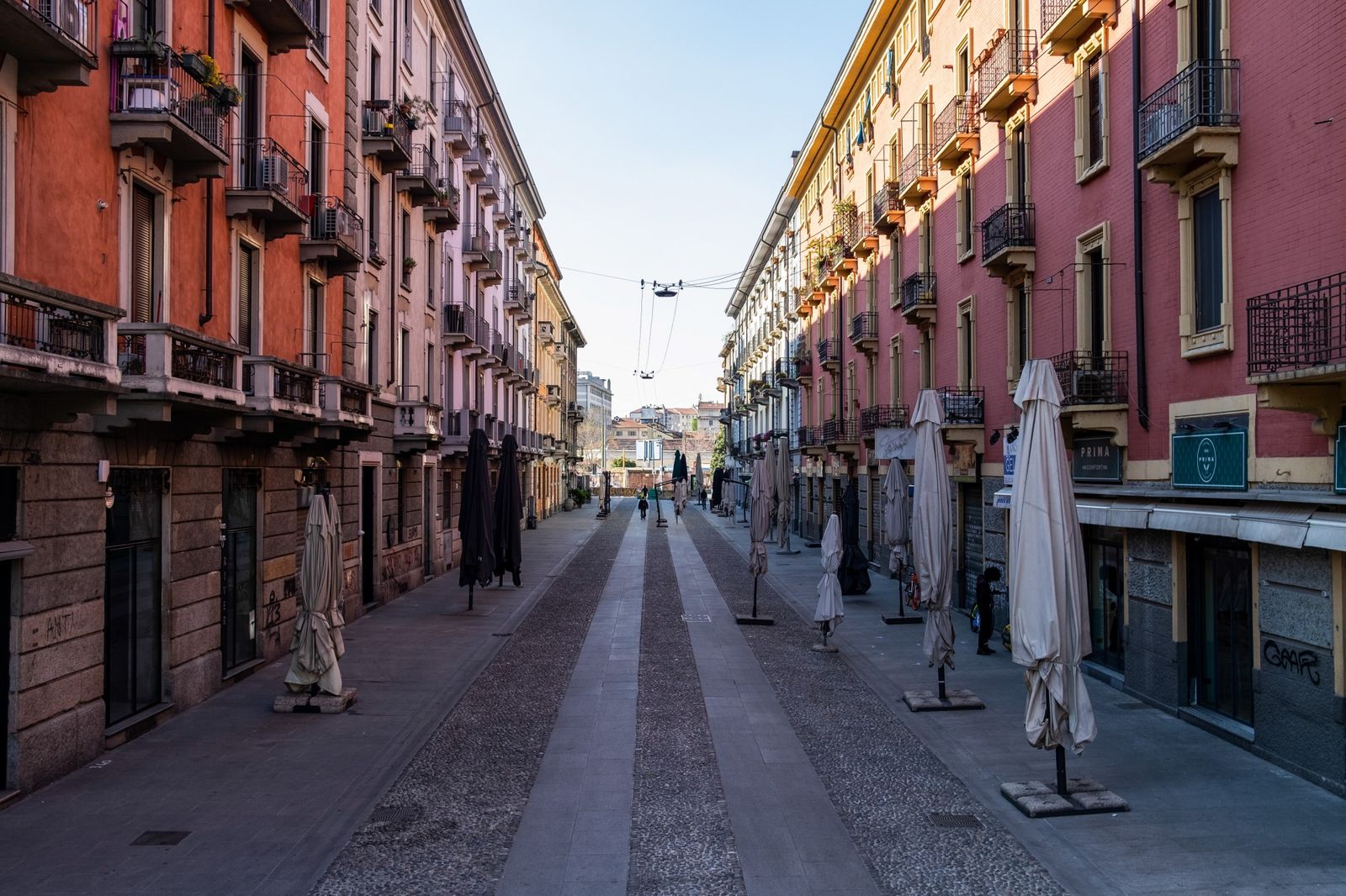 Umbrellas outside closed cafes line a street leading to the Navigli canal system on April 8. (Photographer: Francesca Volpi/Bloomberg)