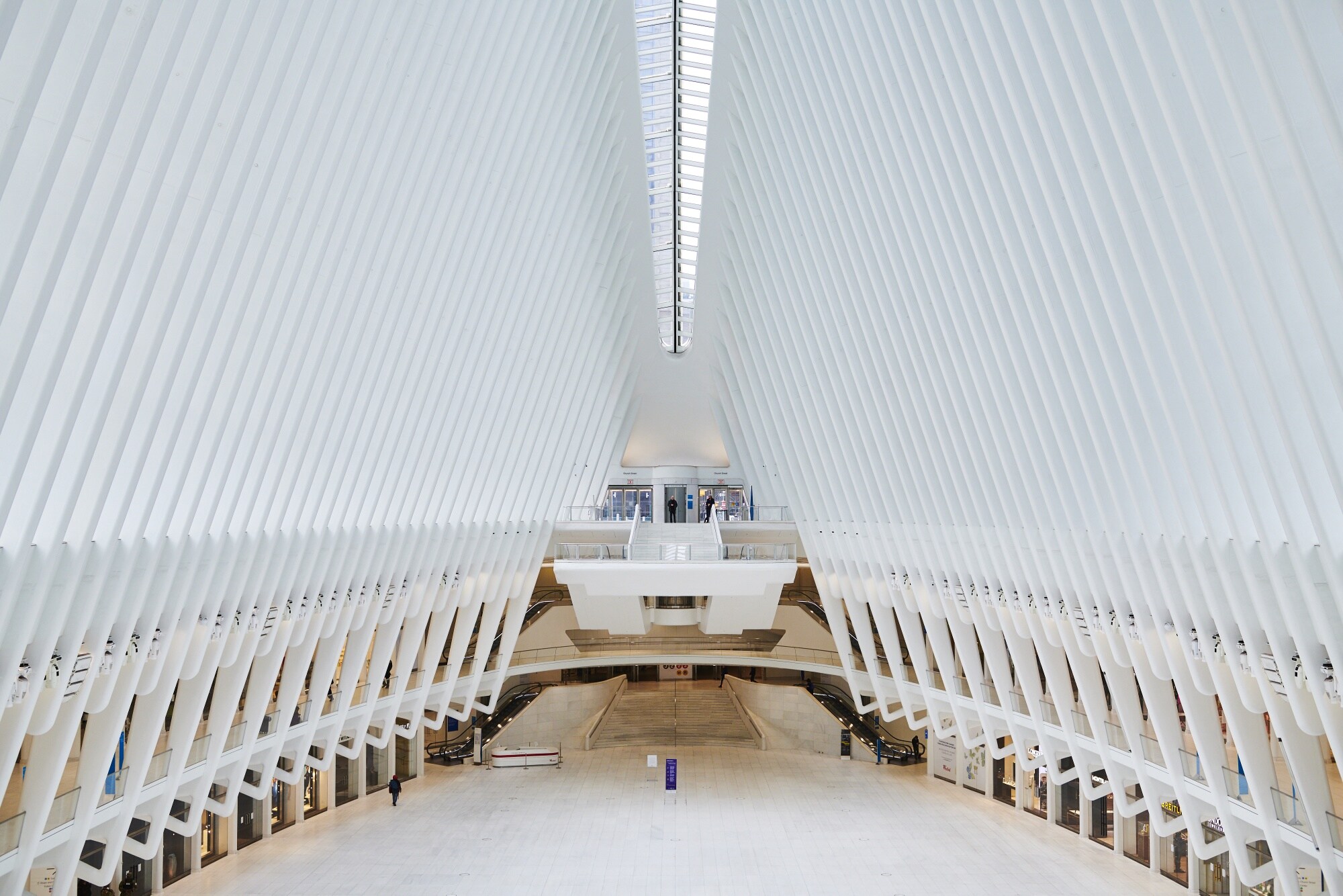 A lone pedestrian walks inside the Oculus, a transportation and shopping hub in Manhattan's financial district on March 30. (Photographer: Gabby Jones/Bloomberg)