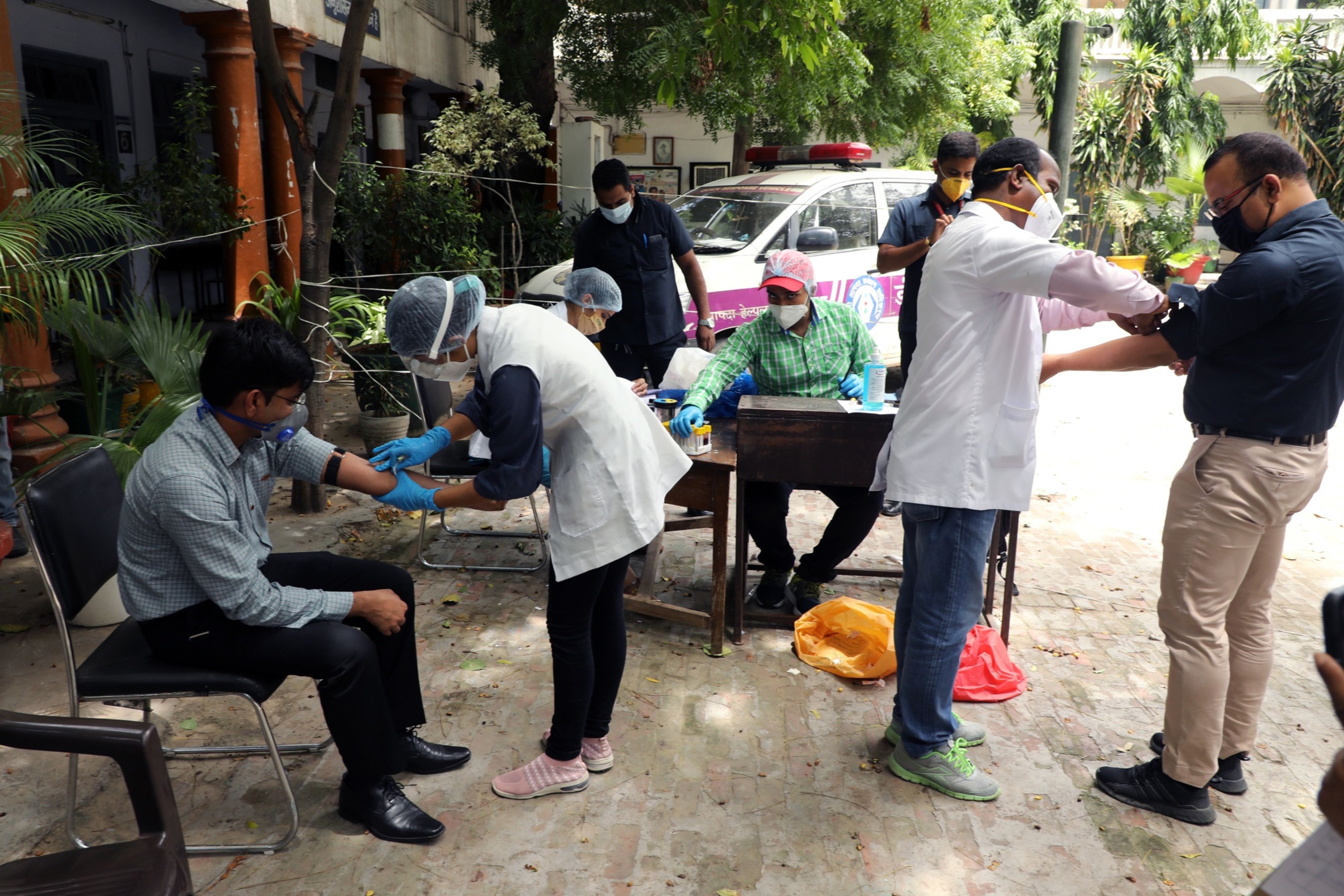 Health workers take blood samples from local residents at a serological survey site in New Delhi, on Aug. 6, 2020. (Photographer: T. Narayan/Bloomberg)