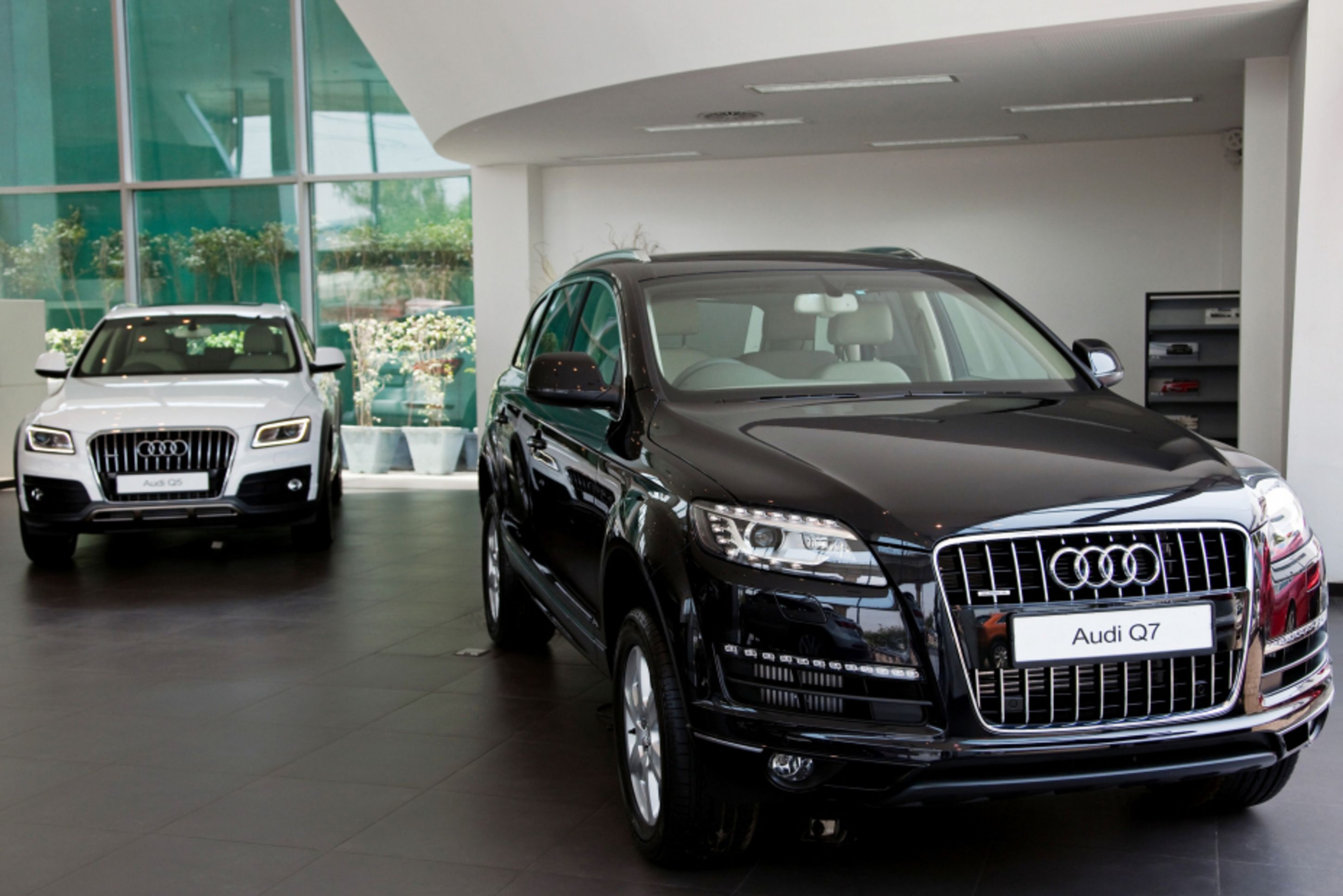 The Volkswagen AG Audi Q7 sport-utility vehicle (SUV), right, and the Audi Q5 SUV stand on display inside the Audi Delhi South dealership in New Delhi, India. (Photographer: Graham Crouch/Bloomberg)