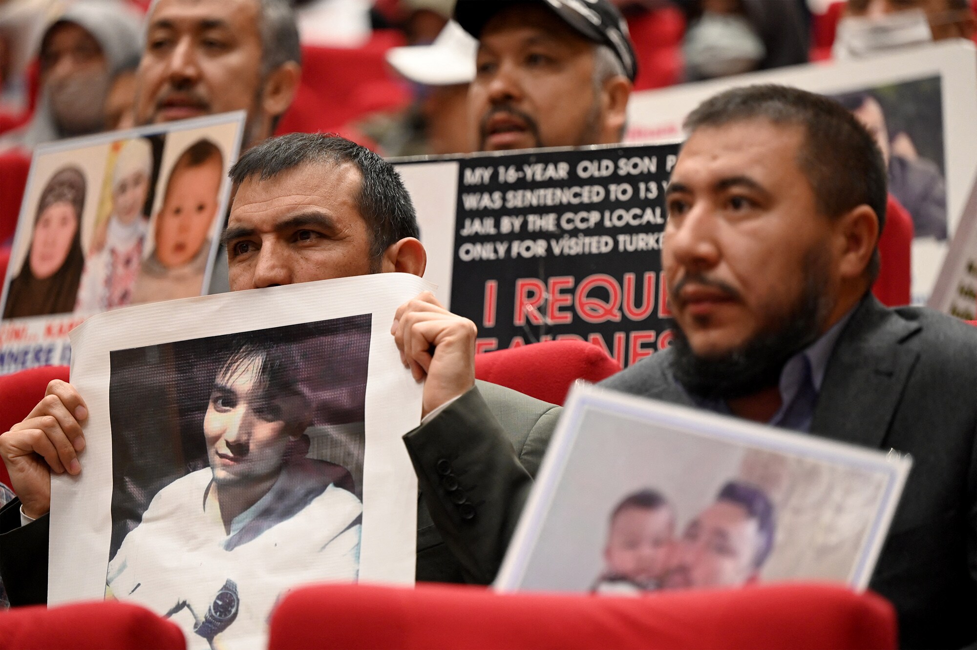 Members of the Uyghur minority display pictures of their relatives detained in China during a press conference in Istanbul, on May 10, 2022.Photographer: Ozan Kose/AFP/Getty Images