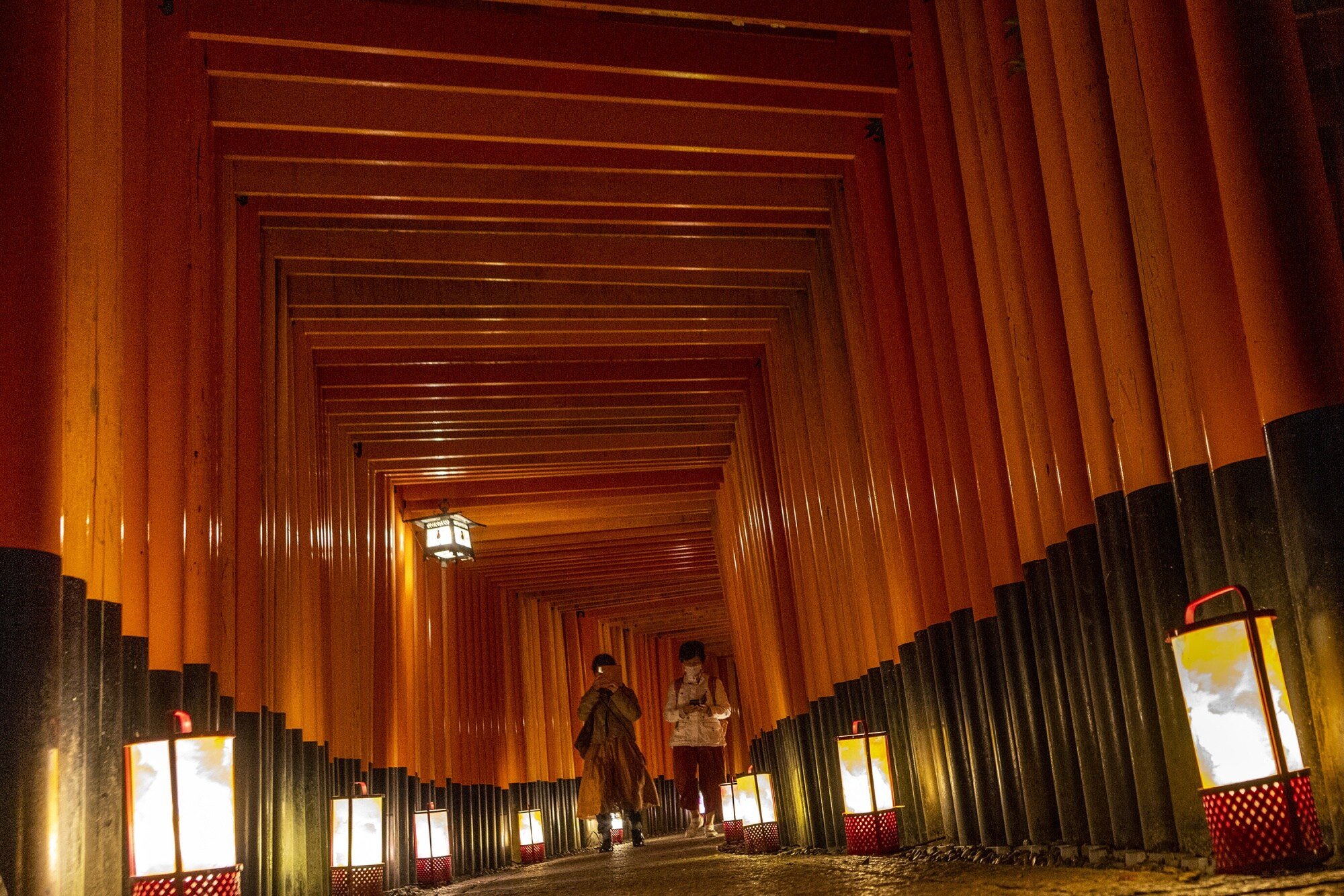 Tourists walk through the Torii path at Fushimi Inari-Taisha shrine, in Kyoto on Oct. 8.Photographer: Buddhika Weerasinghe/Getty Images