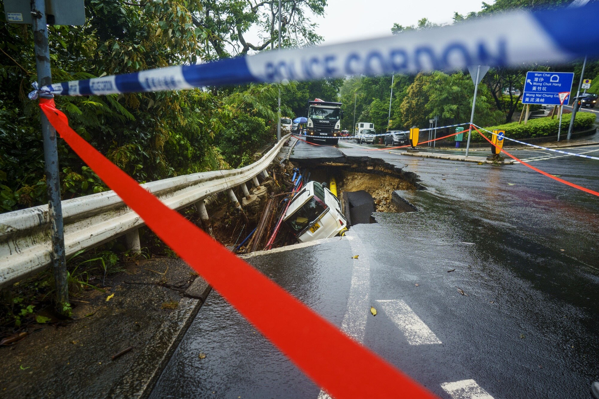 A vehicle in a sinkhole caused by heavy rains in Hong Kong.Photographer: Justin Chin/Bloomberg