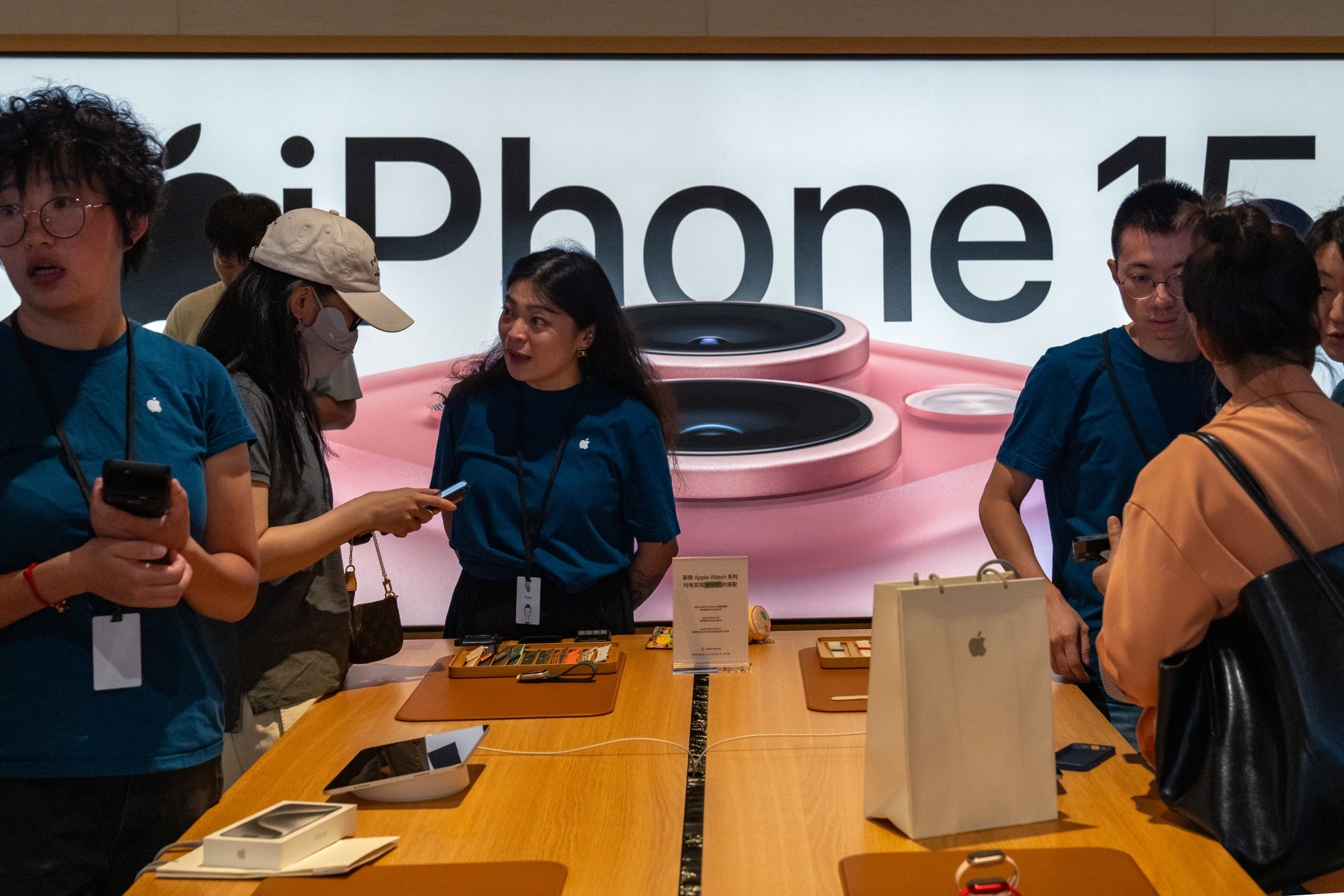 Employees assist customers at an Apple store during the first day of sale of the iPhone 15 smartphone in Beijing on Sept. 22.Photographer: Andrea Verdelli/Bloomberg