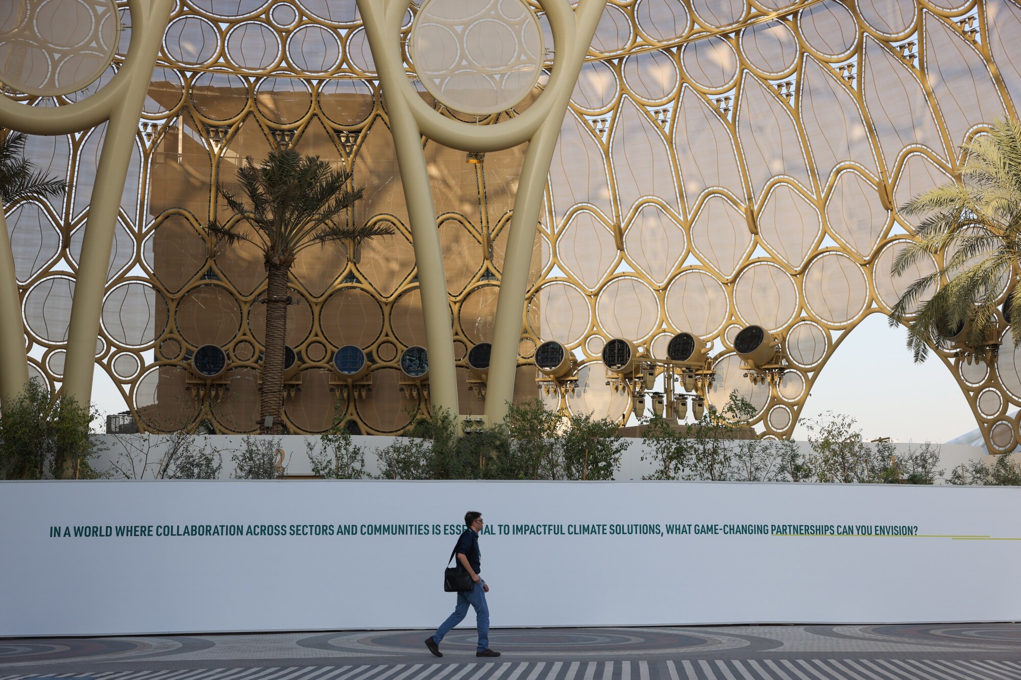 An attendee walks across a plaza in Expo City in Dubai ahead of the COP28 climate conference.Photographer: Hollie Adams/Bloomberg