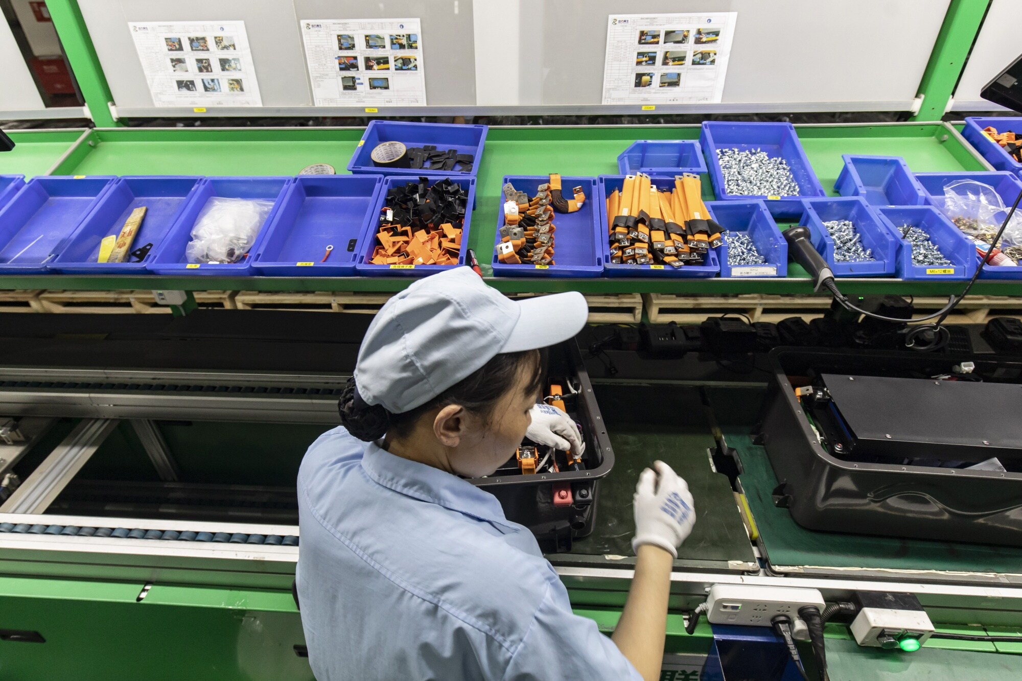 Workers assemble new batteries for power banks made out of old vehicle batteries at a battery recycling plant in Wuhan in Sept. 2023. Photographer: Qilai Shen/Bloomberg