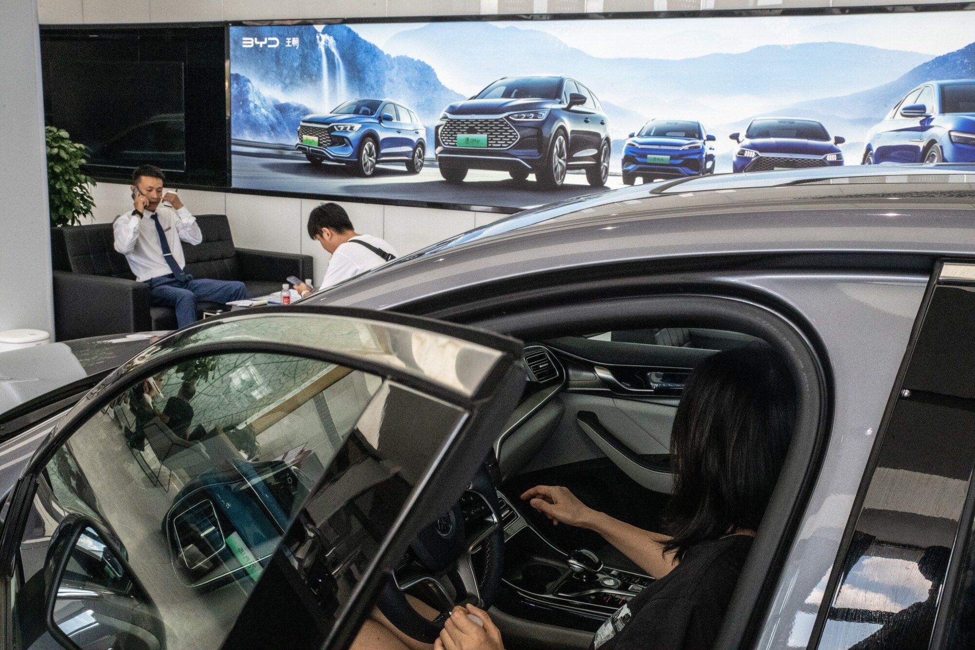 A customer tries a BYD electric vehicle at a dealership in Beijing.Source: Bloomberg