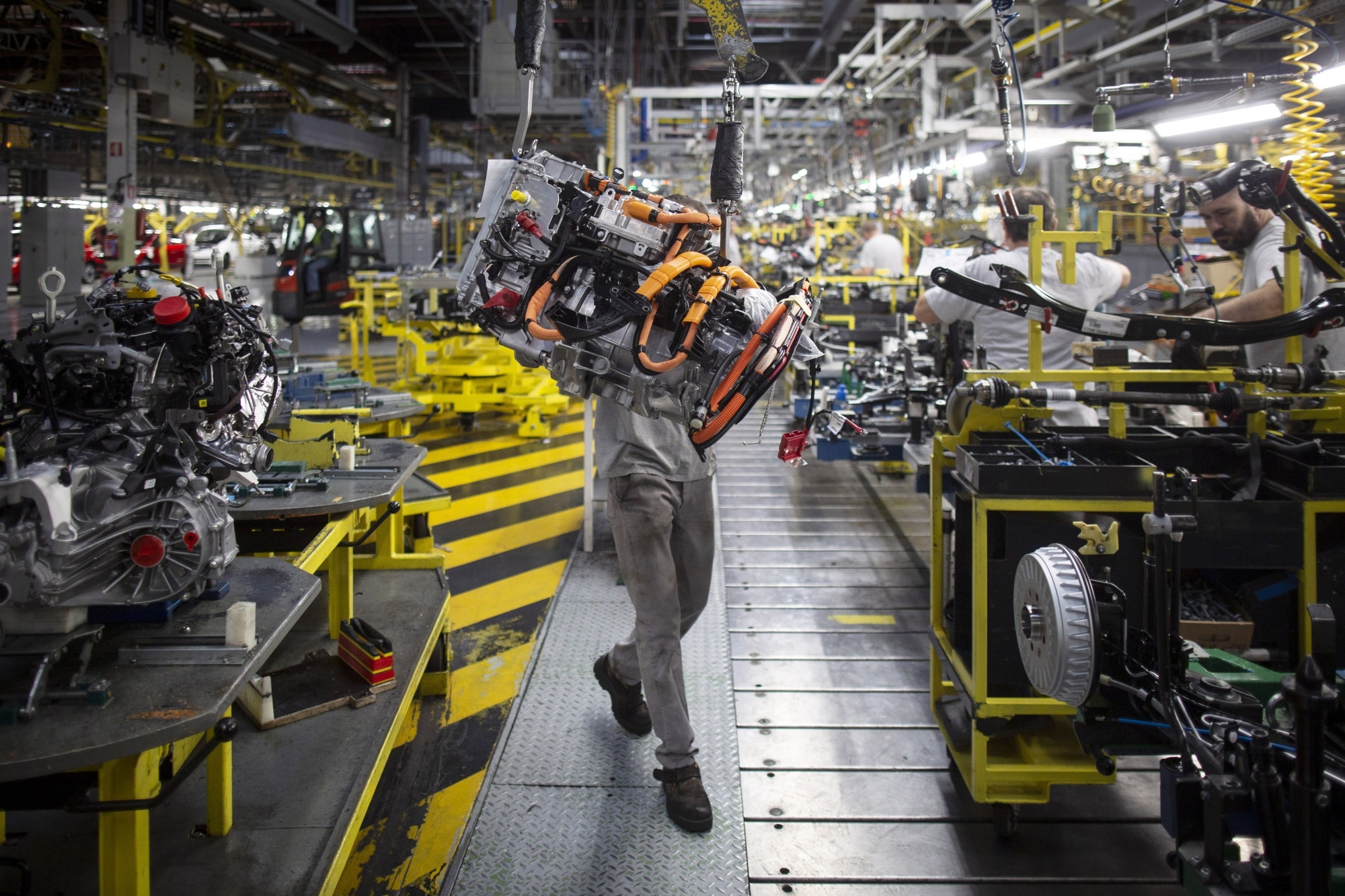 An employee uses a winch to mount the drive train system of a Renault Twingo Electric automobile at the Renault Revoz d.d. plant in Novo Mesto, Slovenia.Photographer: Oliver Bunic/Bloomberg