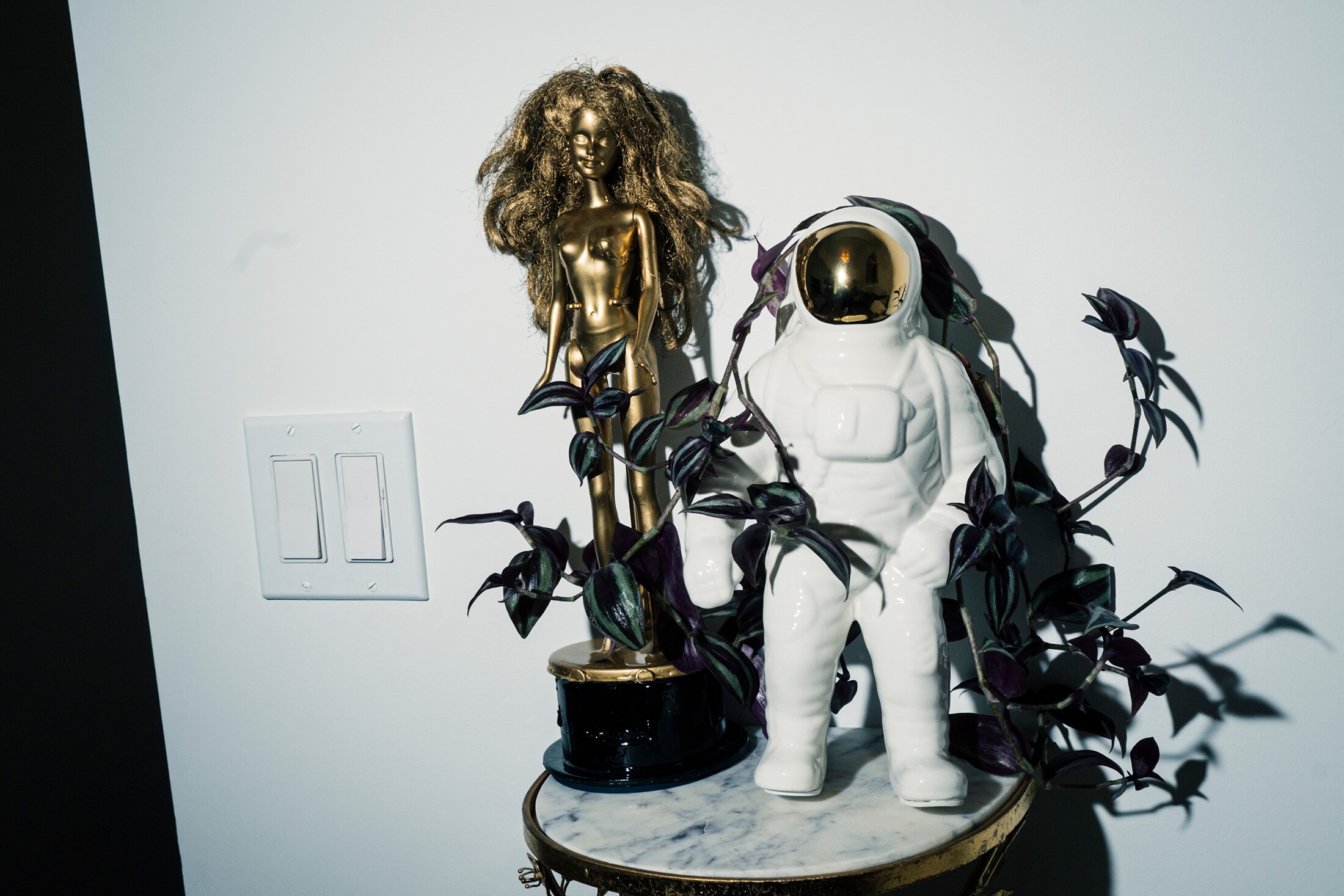 A golden Barbie doll and astronaut sculpture adorn Roman and Erica's office.Photographer: Jutharat Pinyodoonyachet for Bloomberg Businessweek