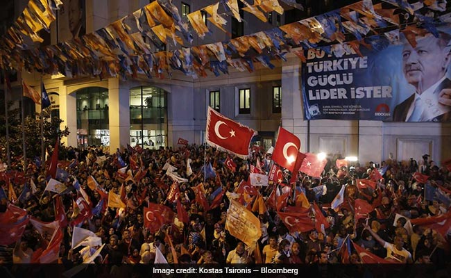 Supporters of Erdogan celebrate in the streets after the party claimed victory in the presidential polls